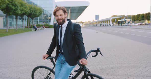 Man in Stylish Clothes Posing on His Bike in the Middle of Pedestrian Path