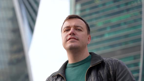 Millennial Guy Looking at Camera Smiling and Waving Hello Greeting Gesture Standing at City Street