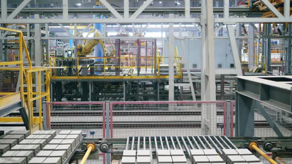 Robotic Arms Move Pallets with Bricks at a Modern Industrial Plant.