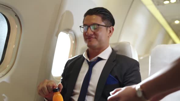 Businessman Have Orange Juice Served By an Air Hostess in Airplane