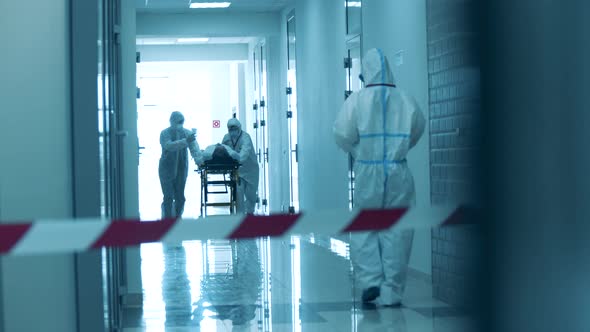 Paramedics Are Taking a Patient Through a Hall Under Lockdown