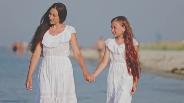 Mom and Daughter Walking By the Sea