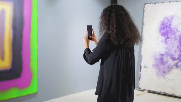 Female Guest of Art Gallery Is Taking Photo of Picture By Smartphone