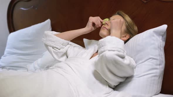 Woman Lying in Bed, Putting Cucumbers on Eyes, Natural Beauty Procedure, Renew