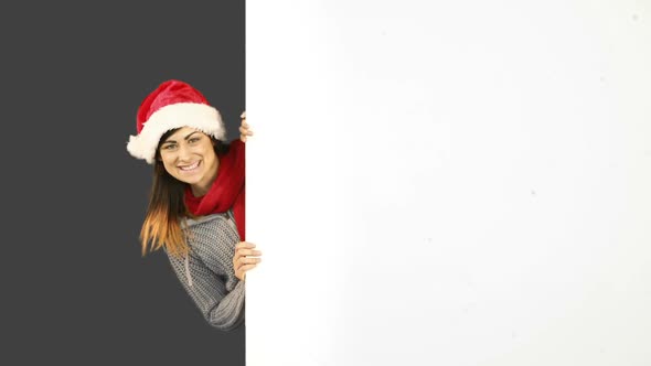 Beauty brunette in santa hat showing white poster