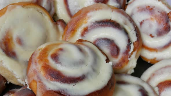 Round Homemade Baked Cinnabons with White Icing on Top Close Up View