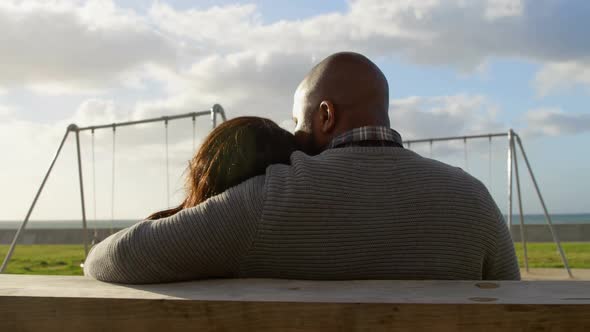 Rear view of couple sitting on bench in the park 4k