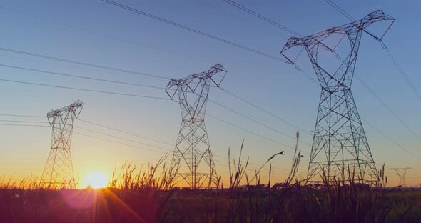 Time lapsed of electricity pylon on a field during sunset 4k