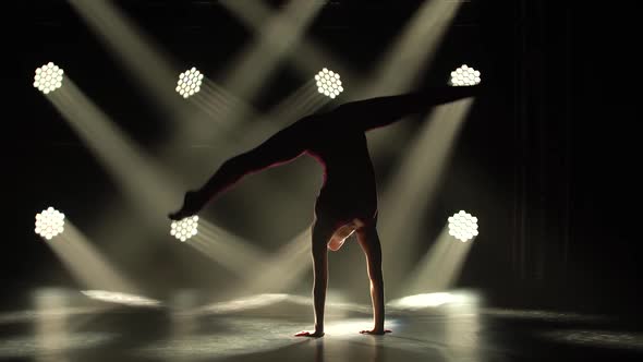 Acrobatic Exercises Performed By a Young Flexible Female Rhythmic Gymnast. A Dark Silhouette