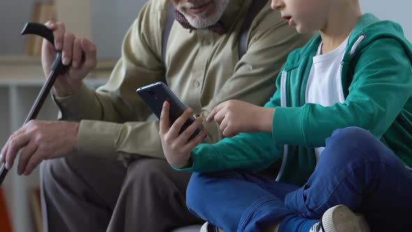 Male Kid Showing Grandfather How to Use Smartphone Application, Communication