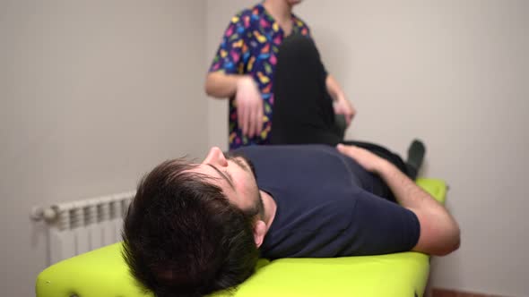 physiotherapist doing stretching exercises on a stretcher with patient