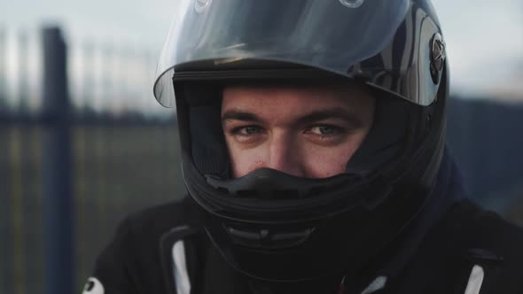 Portrait of Young Attractive Motorcyclist with Black Helmet on Street