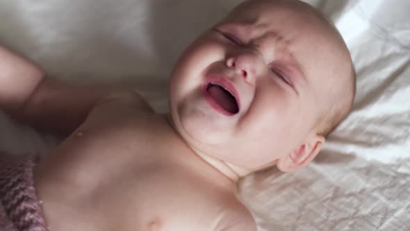 A Small Child with Colic in the Stomach. Toddler Baby Crying with Stomachache Pain.