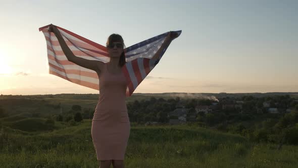 Happy woman with USA national flag outdoors at sunset, Positive girl celebrating United States 