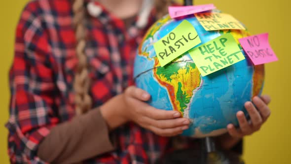 Closeup Earth Globe with Adhesive Notes Expressing Ecological Issues in Hands of Unrecognizable