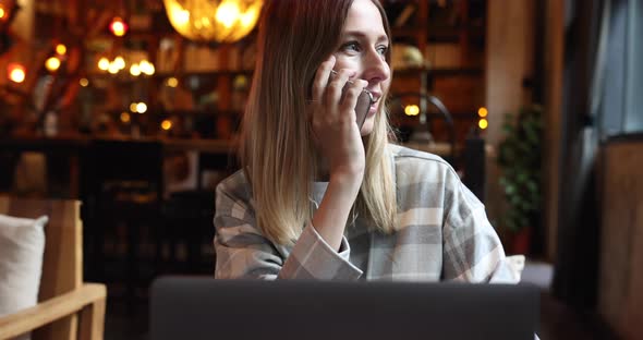 Young Caucasian Business Woman with Blonde Hair Working on Laptop in Cafe