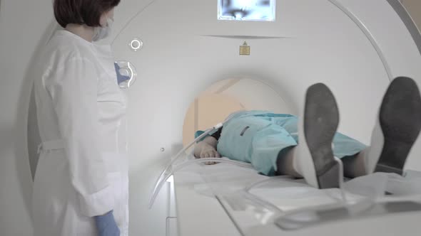 Doctor Makes an MRI Scan for a Patient in a Clinic