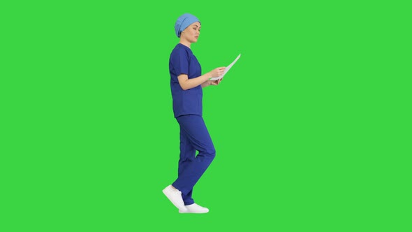 Female Professional Doctor or Nurse Reading Medical Form While Walking on a Green Screen Chroma Key