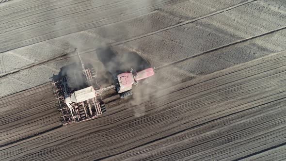 Agriculture Farm Tractors Plow the Earth in Field Dust in the Field View From Height Grain Sowing