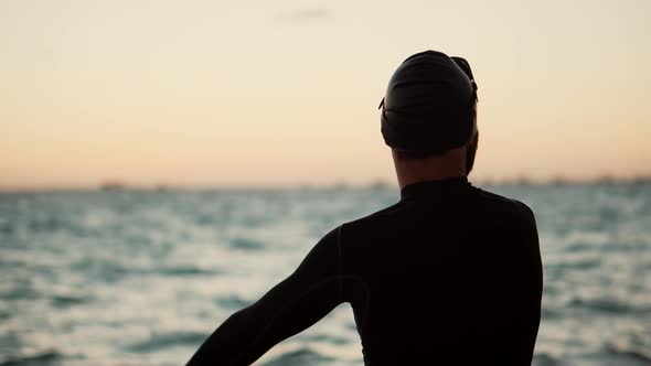 Triathlete Silhouette Stretching Preparing To Triathlon Swim. Swimmer Warming Up Workout.