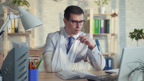 Portrait of a Man Office Worker Wearing Glasses with a Broken Arm