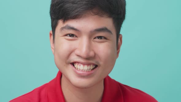 Close up of portrait of attractive Asian young man smiling with isolate green screen in background.