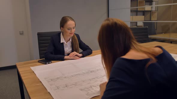 Attractive Young Lady Specialist Engineer Looking at the Drawing