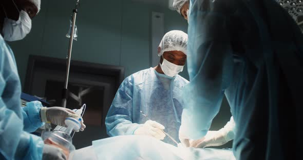 A Team of Surgeons Perform an Operation in a Bright Operating Room