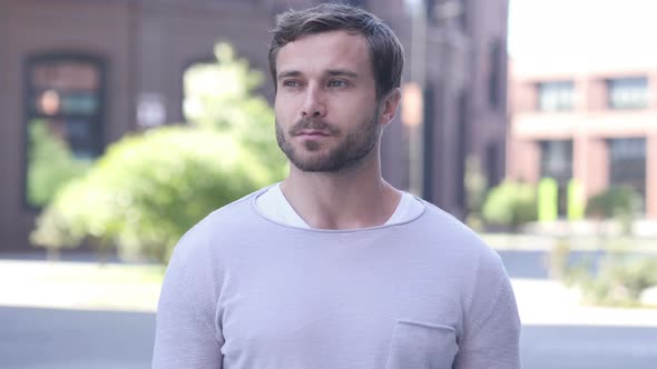 Serious Handsome Man Standing Outside Looking Around