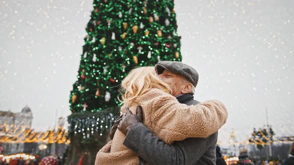 Close Up Shot of Senior Man and Woman Embracing Enjoying Meeting After Long Separation Against City