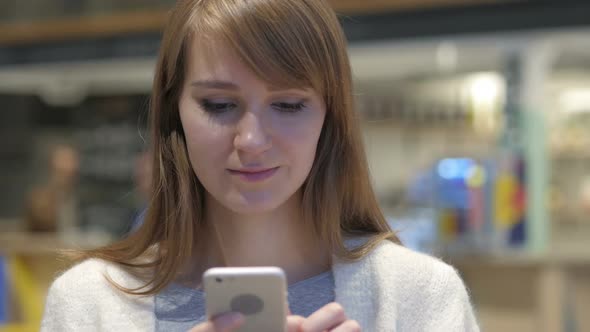 Young Woman Using Smartphone for Online Browsing