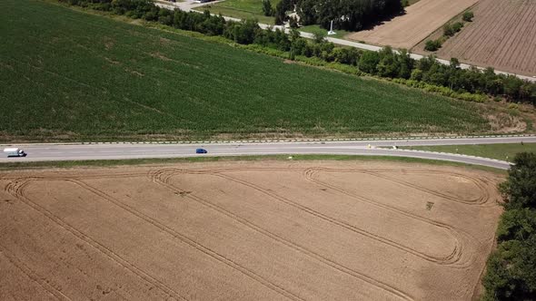 Aerial View of Highway Road Between Meadow and Agricultural Field