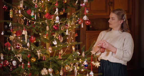Woman Decorating Beautiful Christmas Tree in Living Room