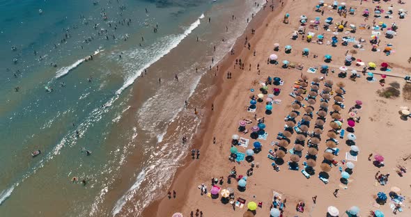 Drone Flies Over Multiple Umbrellas on La Mata Beach in Tourist City in Summer