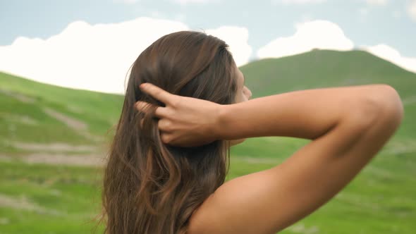 Attractive woman looking out at the beautiful green hills and mountains of Barcelonnette, France.