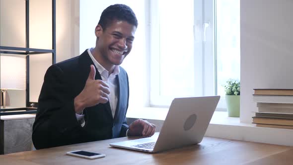 Thumbs Up by Black Man working on Laptop