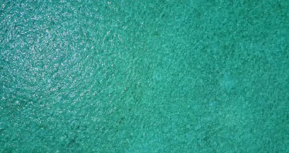 Wide angle overhead travel shot of a paradise sunny white sand beach and aqua turquoise water backgr