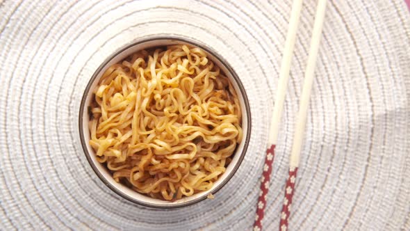 Noodles in a Bowl with Chopsticks on Table