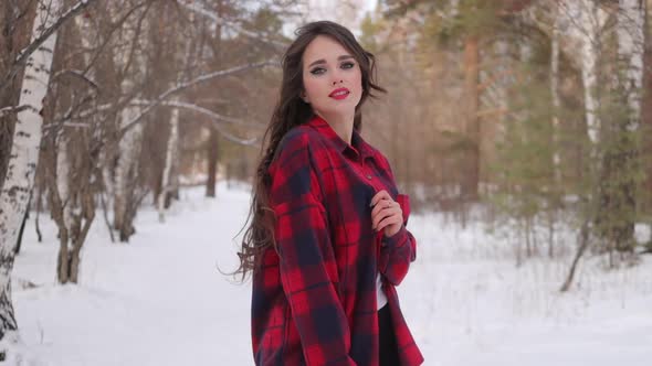 Female in Checkered Shirt Walking in Snowy Park