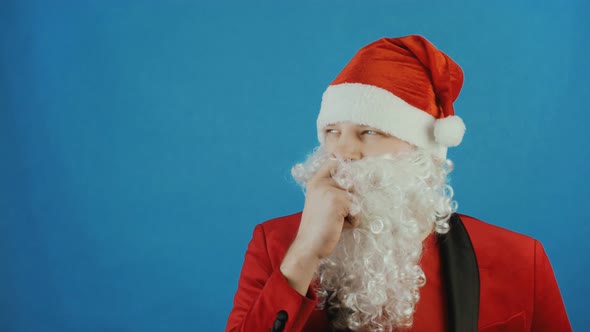 Christmas and New Year, Wondered Man Like a Santa Thinks and Ponders, on Blue Background