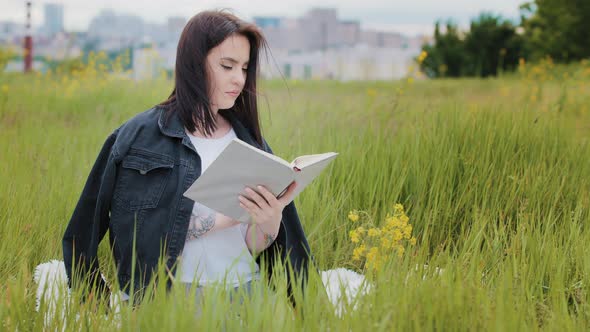 Intelligent Caucasian Woman Sits on Lawn Outdoors Reads Book Literature Psychology Bestseller alt