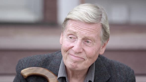 View of elderly mans face as he sits on stairs