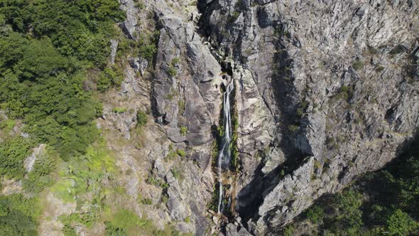 Frecha Mizarela cascade in Portugal, aerial ascending flyback view