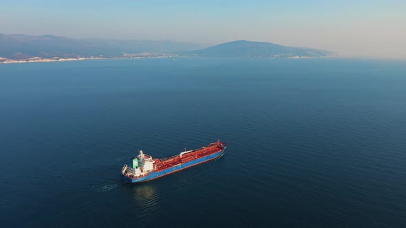 Aerial View of Large Cargo Ship Leaving Sea Harbour at Sunny Day