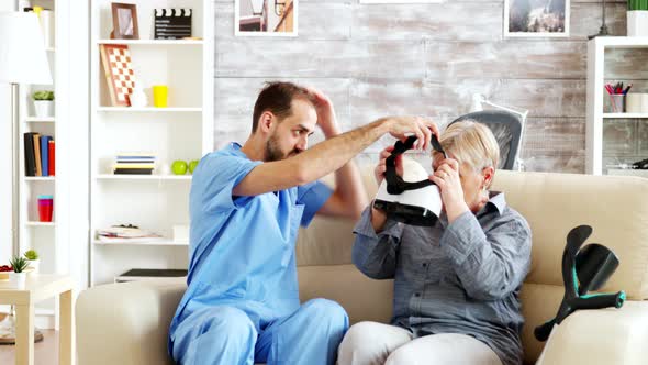 Male Doctor in Nursing Home Helping Senior Woman