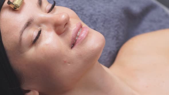 Facial Massage the Cosmetologist Uses a Derma Roller To Lift and Tighten the Skin of the Face