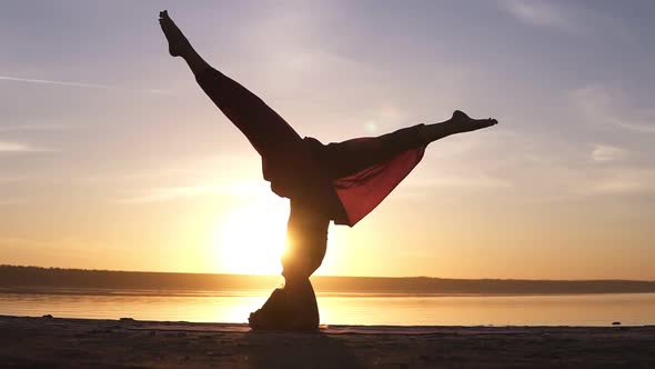 Sporty Beautiful Young Advanced Yoga Woman Standing in Sirsasana Outdoors on the Beach