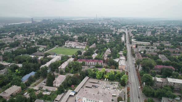 Aerial View of the City Near a Large Industrial Plant with Pipes and Smoke