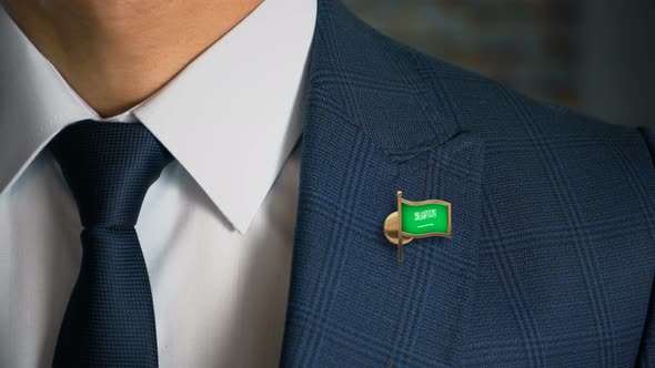 Businessman Walking Towards Camera With Country Flag Pin Saudi Arabia