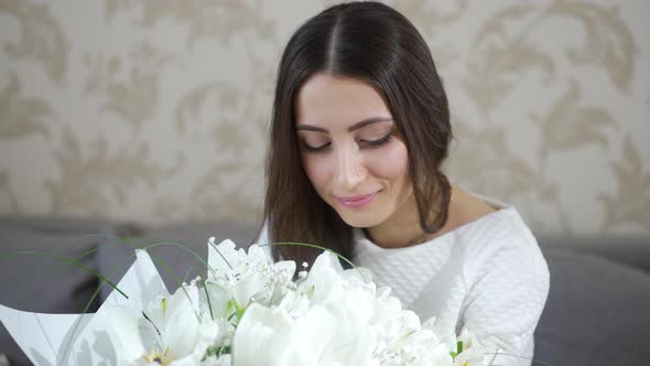 Woman Looks at the Bouquet of Flowers